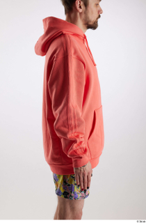 Nigel 1 arm dressed flexing salmon hoodie sweatshirt side view…